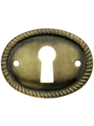Horizontal Oval Keyhole Cover with Rope Design in Antique Brass.